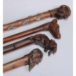 A novelty walking stick, the softwood handle carved as a dogs head and neck, 91cm long; another, the