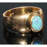 An 18ct gold and opal ring, the central oval cabochon stone with play of colour in blue and green,