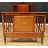 An Edwardian satinwood banded mahogany and marquetry bed, inlaid with a ribbon-tied laurel wreath,