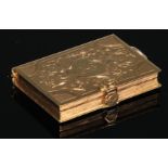 An unmarked gold vinaigrette, as a clasped book, chased and engraved with scrolling foliage,