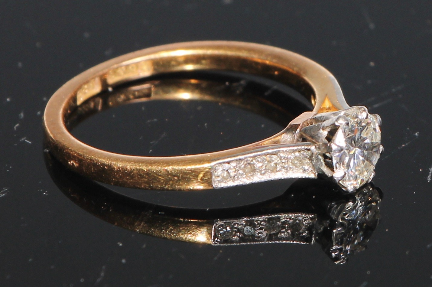 A diamond solitaire ring, set eight further diamonds to shoulders, 18ct yellow gold, size M/N