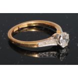 A diamond solitaire ring, set eight further diamonds to shoulders, 18ct yellow gold, size M/N