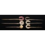 A 19th century pinky red garnet inset horseshoe stickpin, gilt metal mount; others seed pearl, red