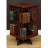 An Edwardian mahogany revolving bookcase, square top with moulded edge above an arrangement of