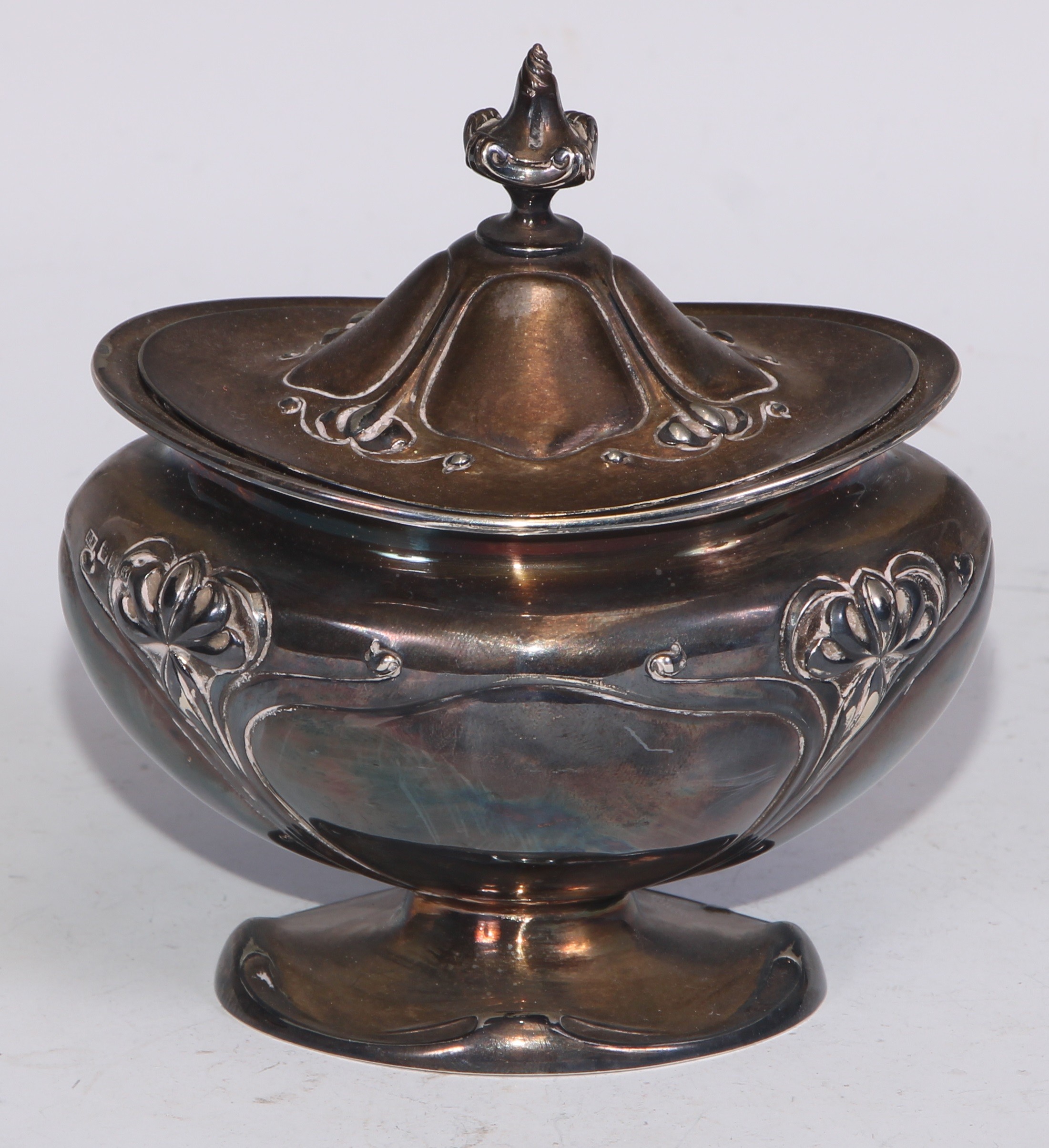 An Art Nouveau silver bombe shaped tea caddy, embossed with stylised flowers on whiplash stems,