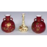 A pair of Derby Crown Porcelain compressed globular vases, decorated in gilt with flowers on a red