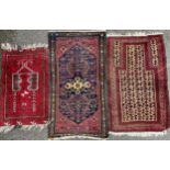 A Middle Eastern woollen rug, in tones of red, b.ue white, 83cm wide, 146cm long; others (3)