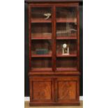 A 19th century mahogany library bookcase, outswept cornice above a pair of glazed doors enclosing