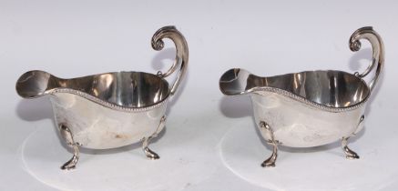 A pair of George VI silver sauceboats, of George III design, acanthus-capped flying scroll