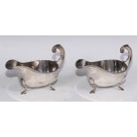 A pair of George VI silver sauceboats, of George III design, acanthus-capped flying scroll