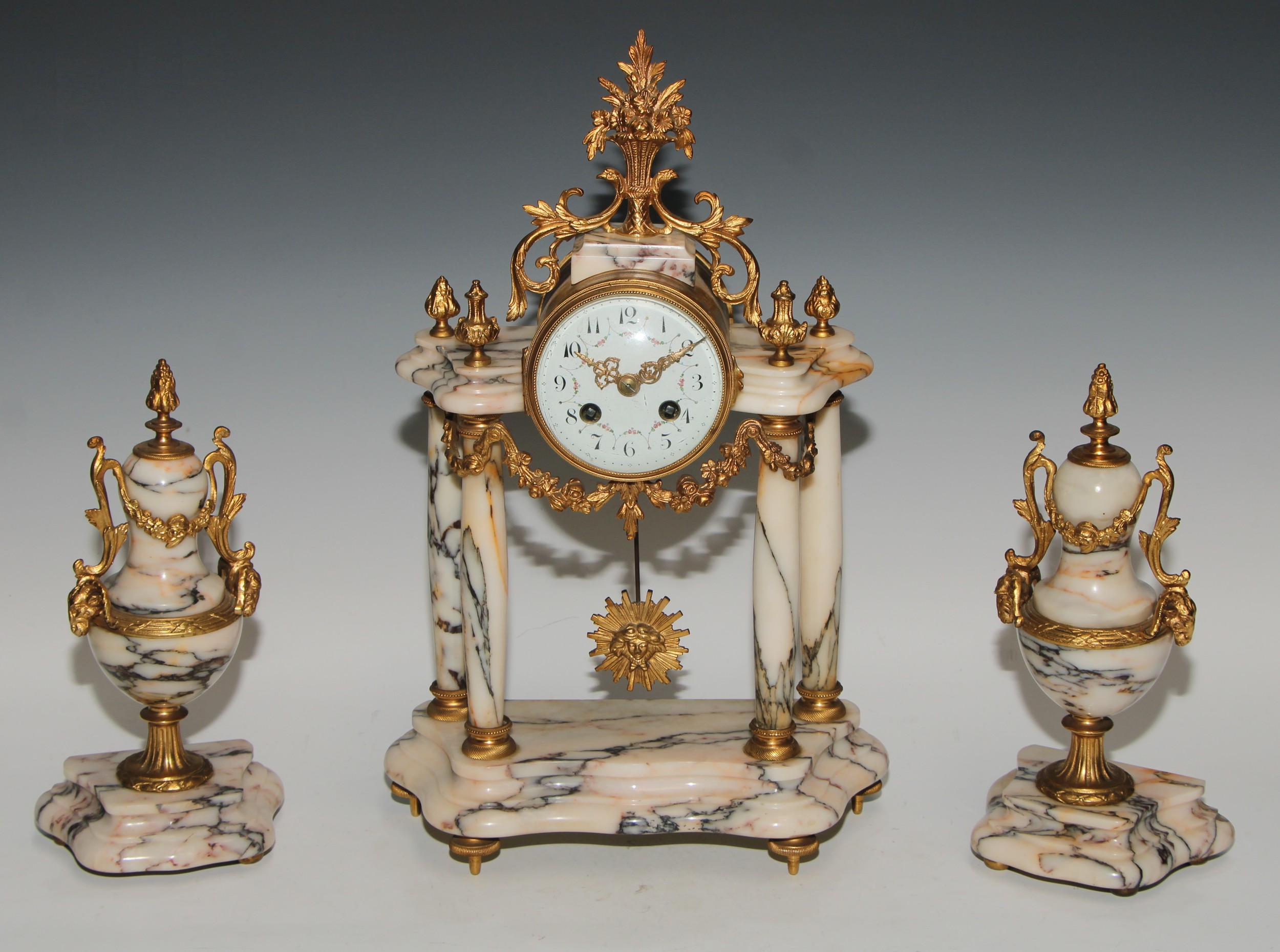 A late 19th century French gilt metal mounted marble portico clock garniture, 8.5cm convex enamel