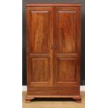 A George III Revival mahogany wardrobe, moulded cornice above a pair of doors set with raised and