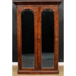 A Victorian walnut wardrobe, outswept cornice above a pair of mirrored doors enclosing a shelf,