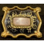 A Victorian shaped rectangular mourning brooch, centre with rounded rectangular hair panel against a