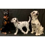 A fireside model of a seated Dalmatian, 44cm; a resin Dalmatian model; another fireside dog model (