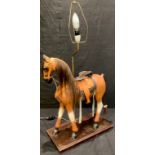 A novelty carved wooden horse table lamp, stepped rectangular wooden base, 53cm high, 41cm wide