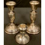 A pair of hallmarked silver candlesticks; a single hallmarked silver candlestick (3)