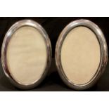 A pair of hallmarked silver oval photograph frames