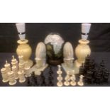 A carved bone chess set; a pair of onyx bookends; a pair of alabaster table lamps; a painted and