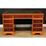 A George III style yew twin pedestal desk, inset tooled and gilt writing surface above three