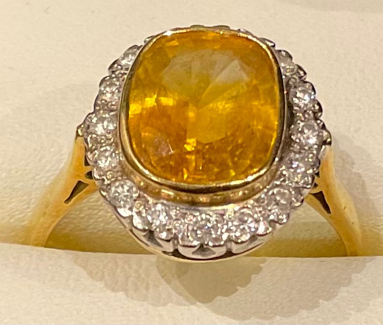 An 18ct gold yellow sapphire and diamond ring, the central cusion cut stone surrounded by sixteen - Bild 2 aus 2