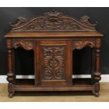 An oak side cabinet, rectangular top with shaped half gallery centred by a Green Man mask flanked by