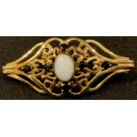 A 9ct gold brooch, set with a central polished opal, surrounded by six smaller sapphires, 4cm, 3.6g
