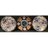 A pair of 19th century Japanese export ware plates, painted with panels of stylised flowers in the