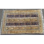 A Persian rectangular woollen rug, with bands of stylised flowers, in tones of green, orange and