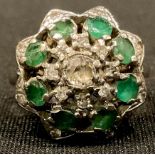 An 18ct white gold diamond and emerald flower head cluster ring, size M, the shank hallmarked London