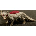 A silver novelty pin cushion, as a fox, ruby eyes, 6cm long