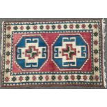 A Middle Eastern woollen prayer rug, with two large geometrical motifs, the border with stylised