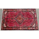 A Persian Tajabad woollen rug, geometric diamond with stylised flowerheads, geometric borders, in