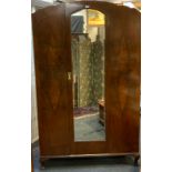 A 1940's walnut wardrobe, single door to centre with arched top bevelled glass mirror, cabriole