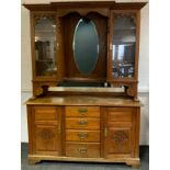 A turn of the century Arts and Crafts style oak dresser, break-front centre to top, with pair of