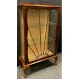 An Art Deco mahogany display cabinet, shaped back, single sun burst door, cabriole ball and claw