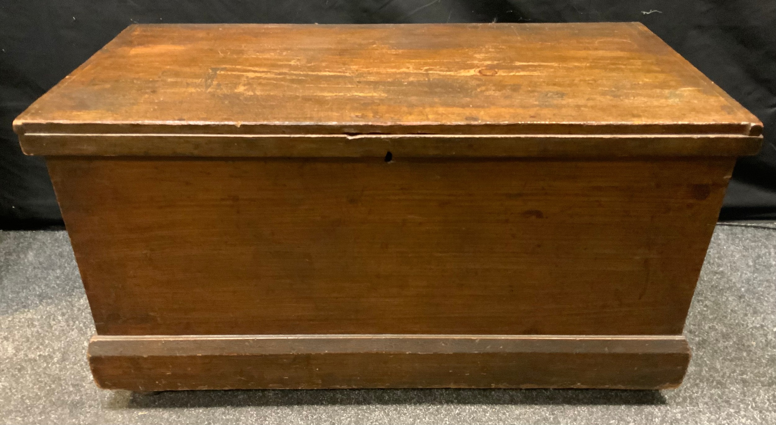 A stained pine tool chest, hinged top, drop loop handles, castor feet, 51cm high, 94cm wide, 46cm