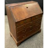 A 19th century oak bureau, the fall front with stepped interior, above two short and three long