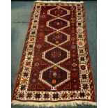 A Middle Eastern woollen rug, with geometric guls, in tones of white, burgundy and red, 240cmcm x