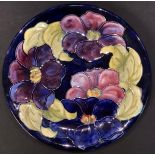 A Moorcroft clematis pattern dish, impressed marks, signed in green, paper label, 26cm diameter