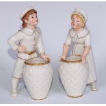 A pair of Royal Worcester figures, of a boy and girl holding a woven basket, lightly coloured in