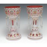 A pair of Bohemian glass lustres, overlaid on cranberry and painted with colourful summer flowers,