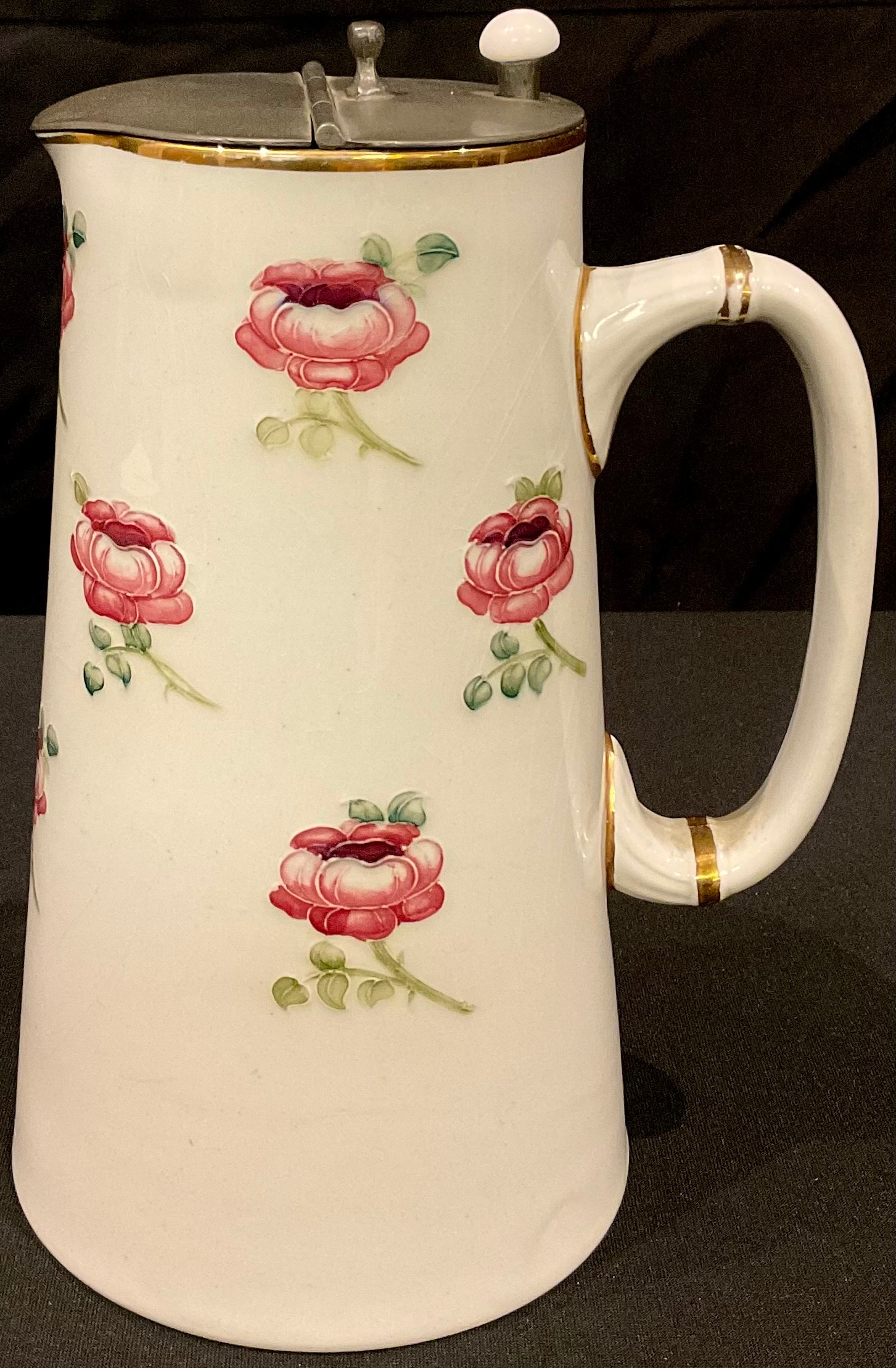A William Moorcroft for James Macintyre tube lined jug, applied with pink rose buds, pewter hinged