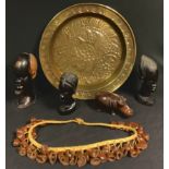 A Nigerian brass tray, 45cm diameter; a Nigerian dancing belt, strung with half nut shells, late