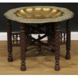 An Indian or North African Berber brass and hardwood folding tray top Benares table, of Mughal