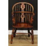 A 19th century Yorkshire elm Windsor elbow chair, low hoop back, shaped and pierced ?Christmas tree?