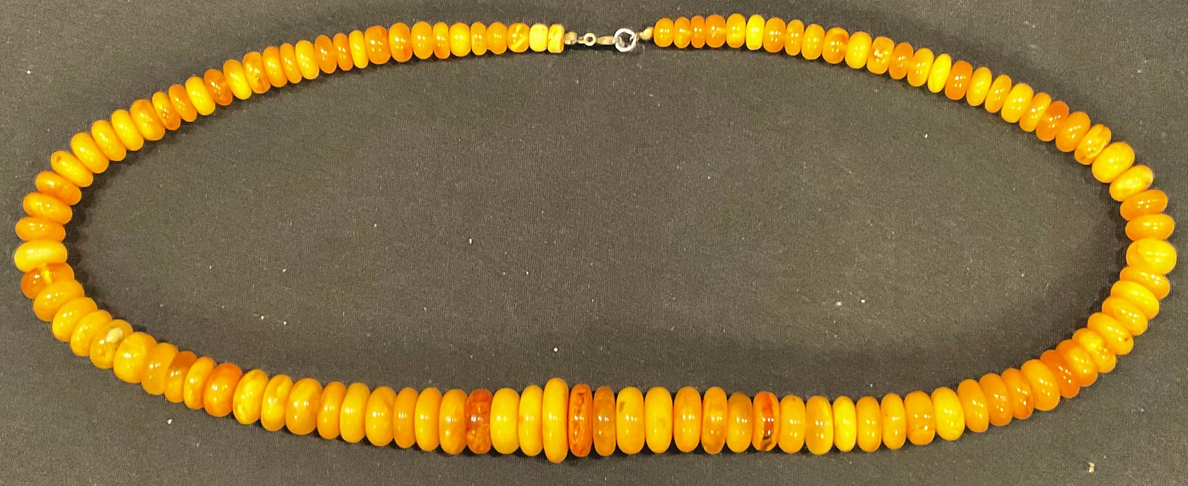 An amber disc necklace, 60cm long, 38g