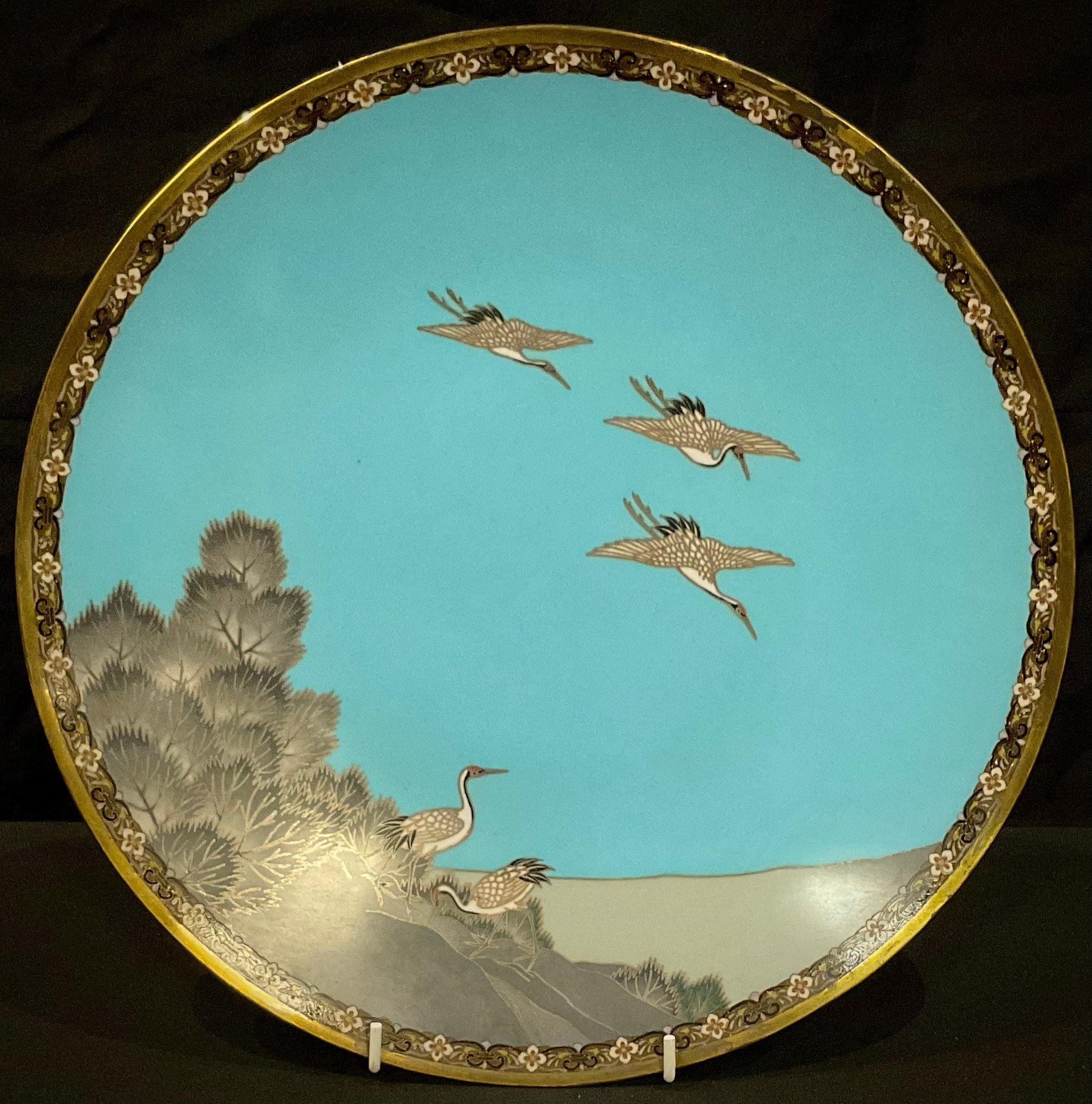 A Chinese cloisonne plate, decorated with cranes in flight, 30cm diameter