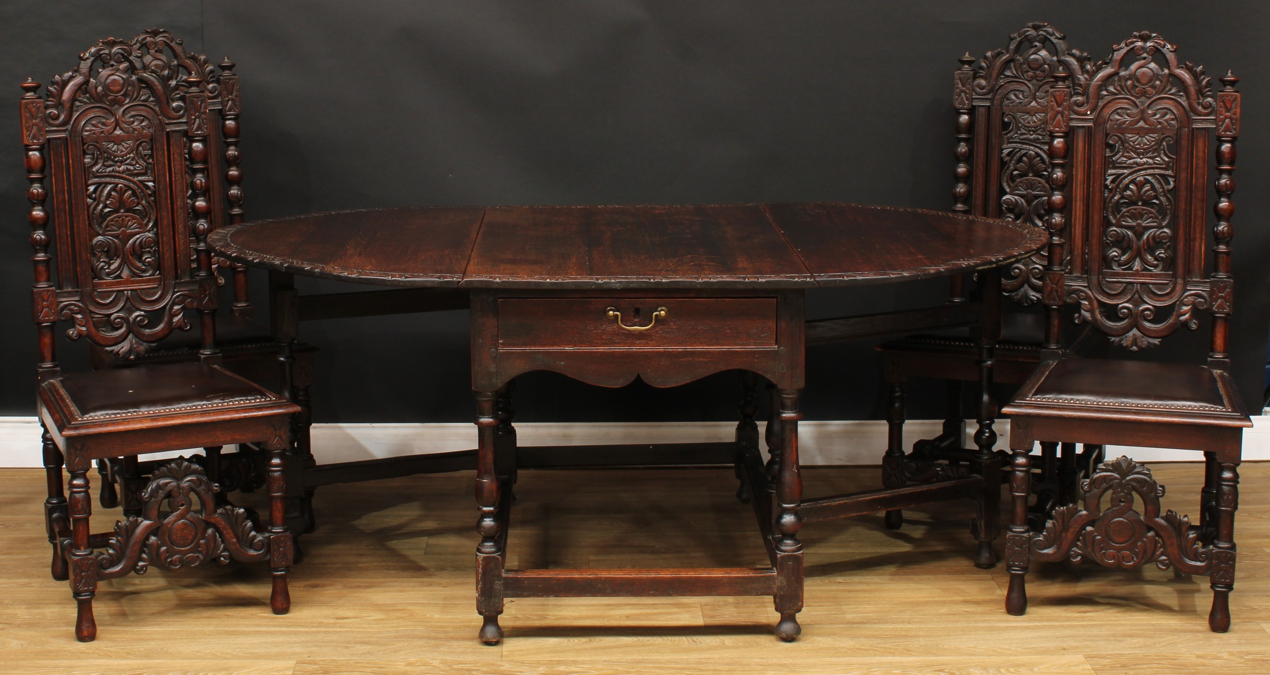 An 18th century oak gateleg dining table, the top with carved edge and fall leaves above a single