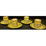 A set of four Aynsley coffee cans and saucers, each can mounted with an Edwardian silver openwork